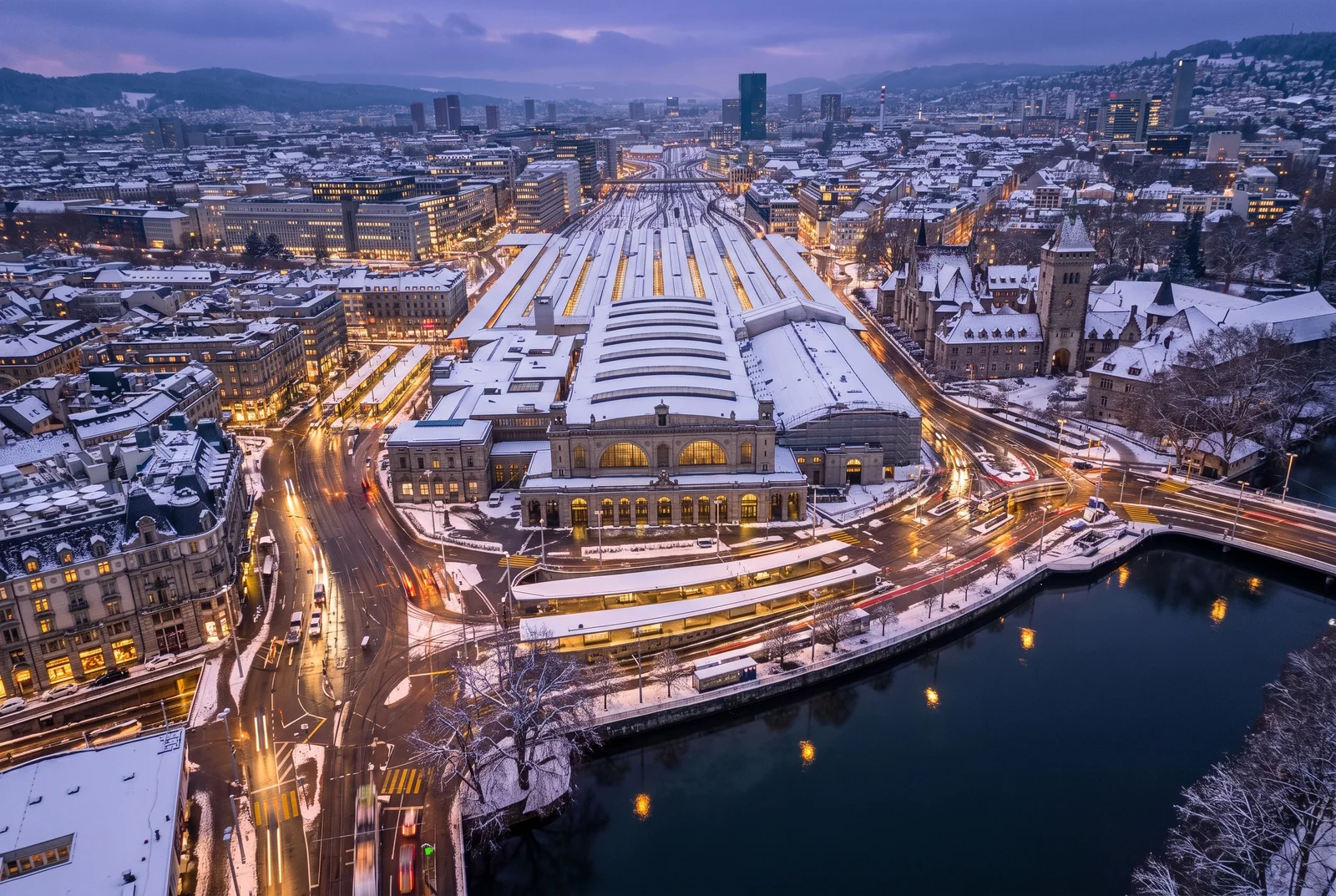Verschneiter Zürich Hauptbahnhof am Winterabend aus der Luft