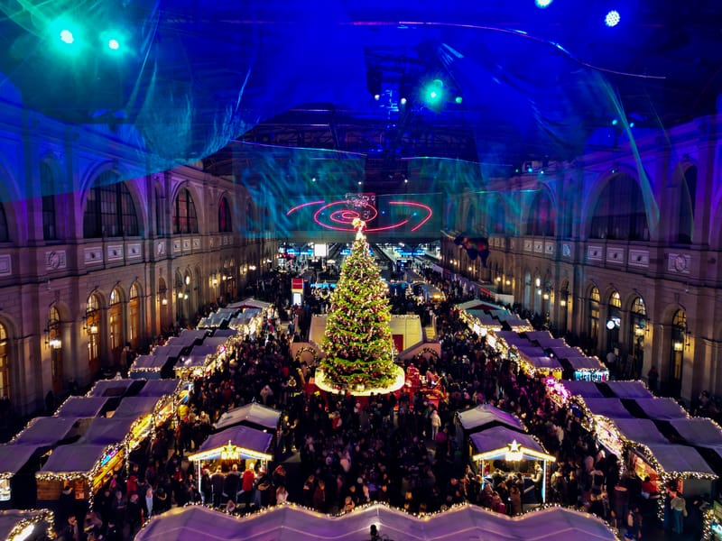 Blick von oben auf den Weihnachtsmarkt mit Lindt Weihnachtsbaum in der Zürcher Bahnhofshalle